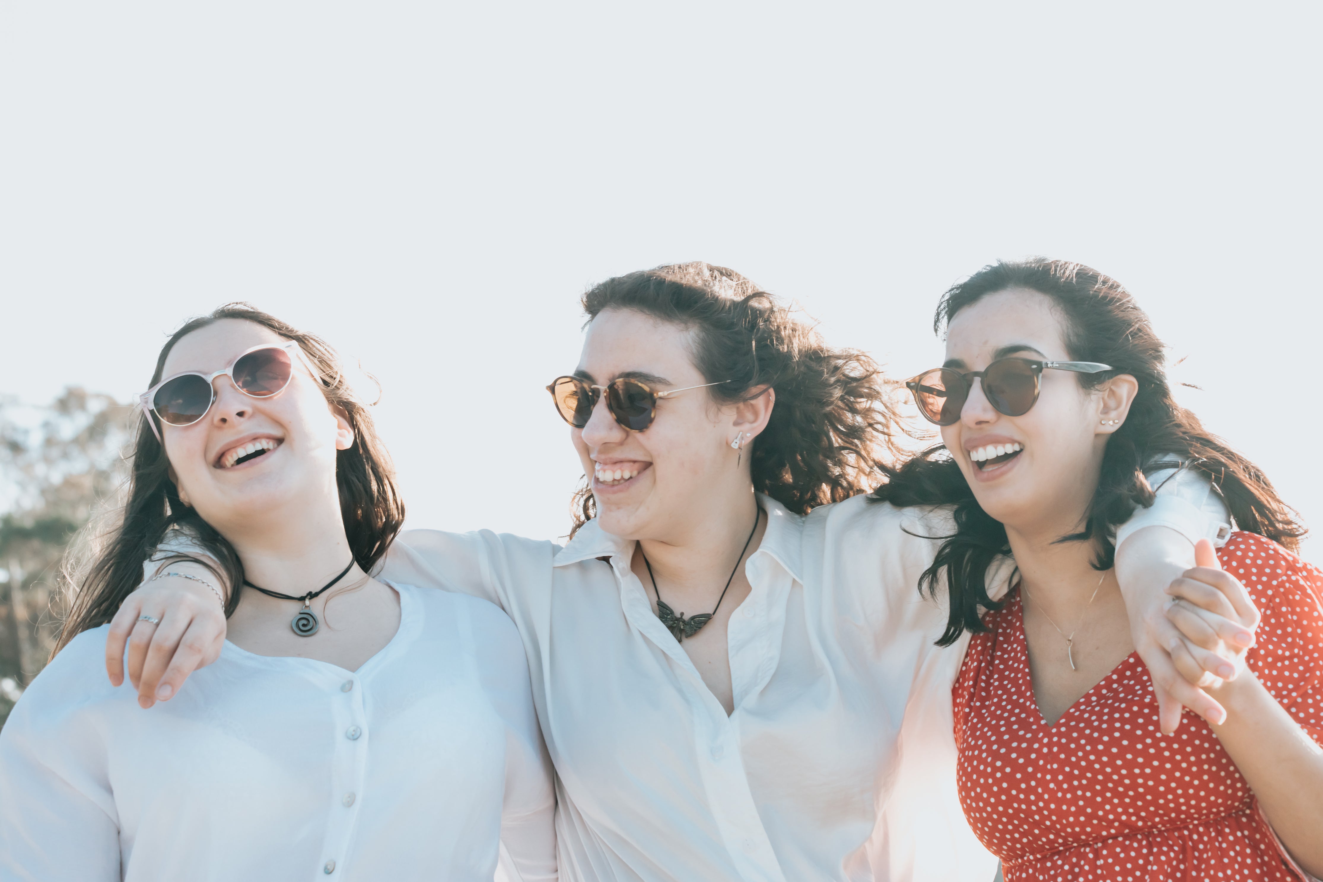 Three friends laughing together outdoors